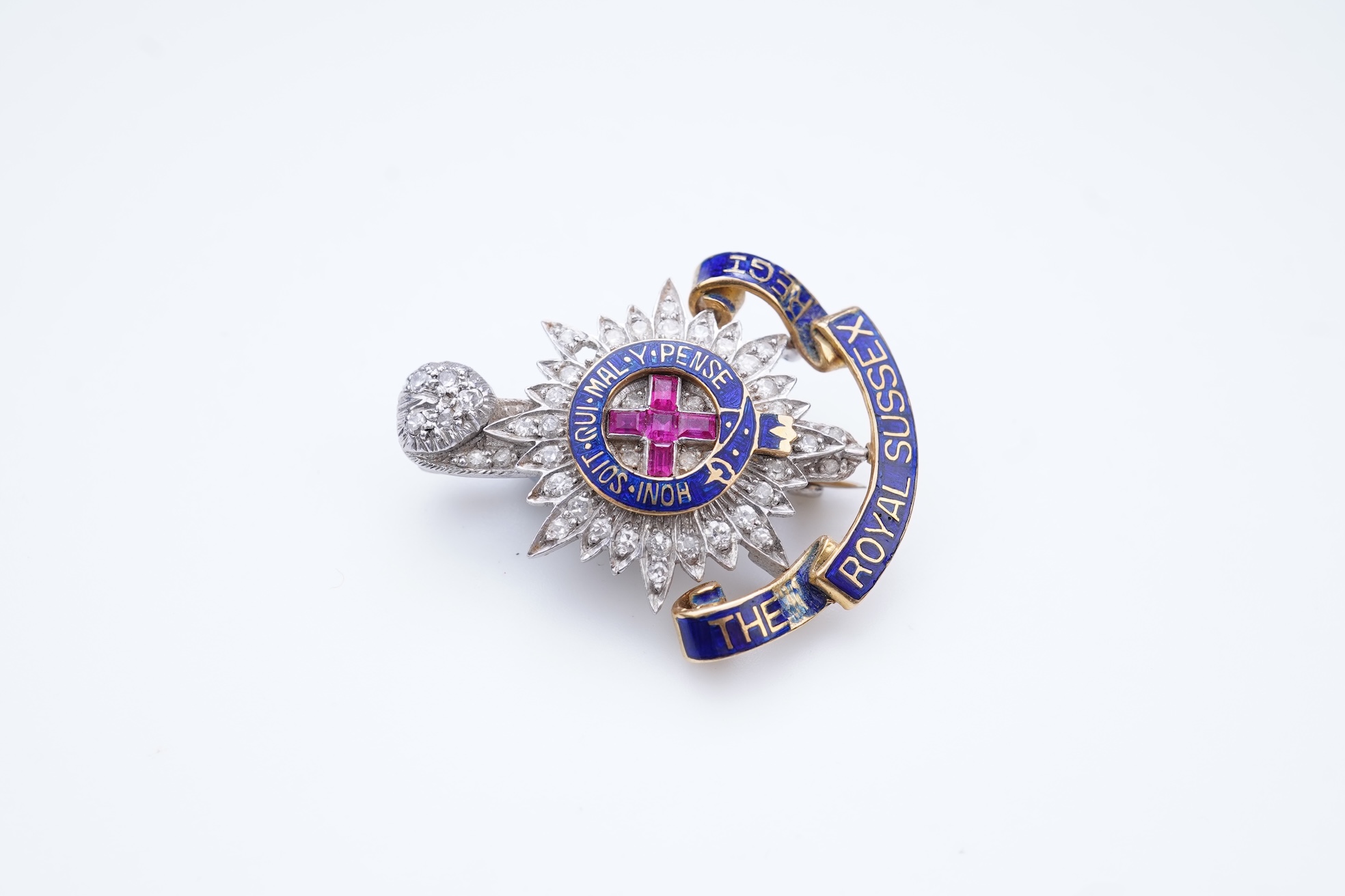 A ruby, enamel and diamond Royal Sussex Regiment badge, mid 20th century